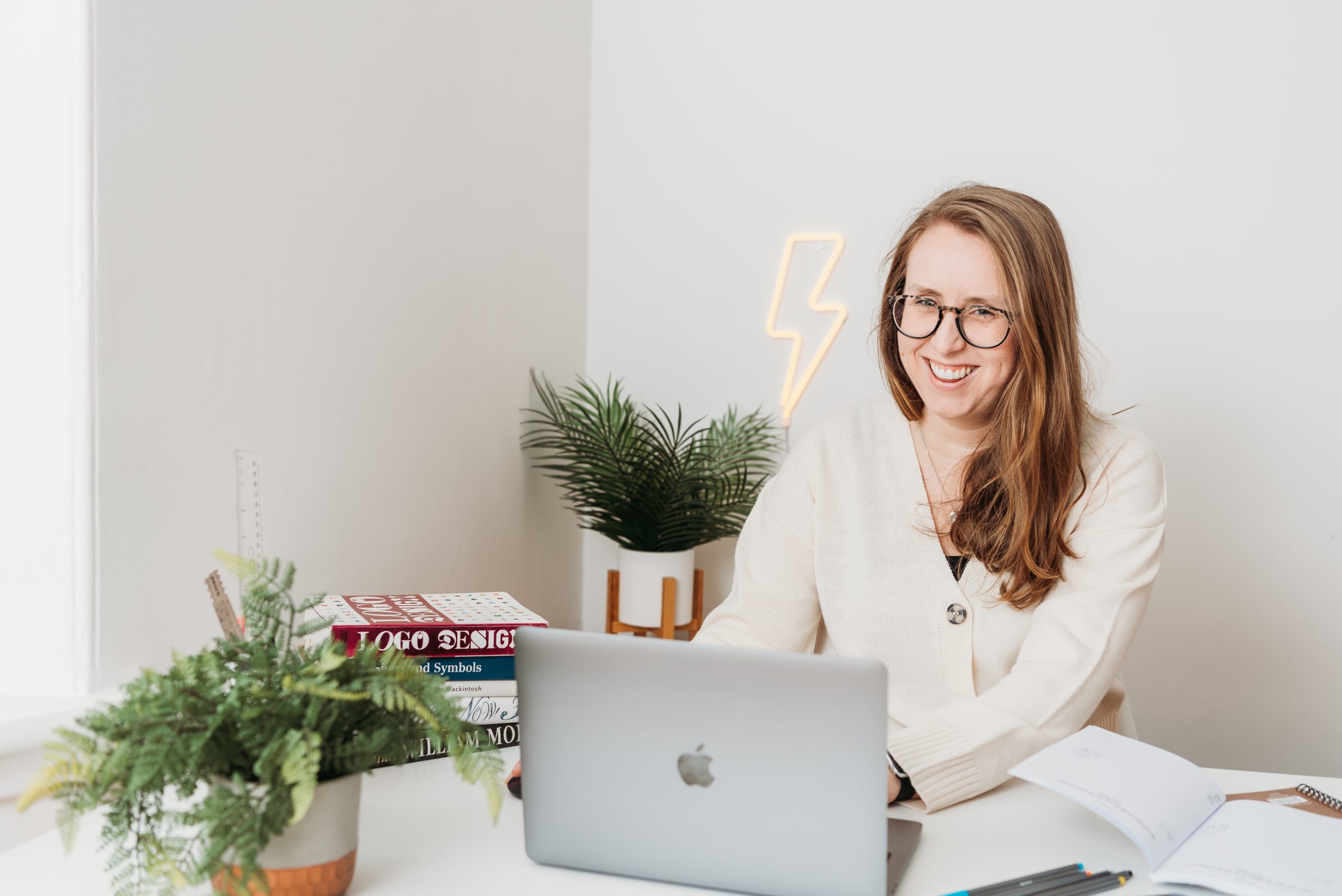 Branded Unconventional Rebel Graphic showcasing a mixture of real images and unconventional graphics showing the process of creating a brand identity. A personal drawing, graphics of a light bulb representing ideas, and arrows showing the final product. A mock-up of the full brand identity on an iPad.